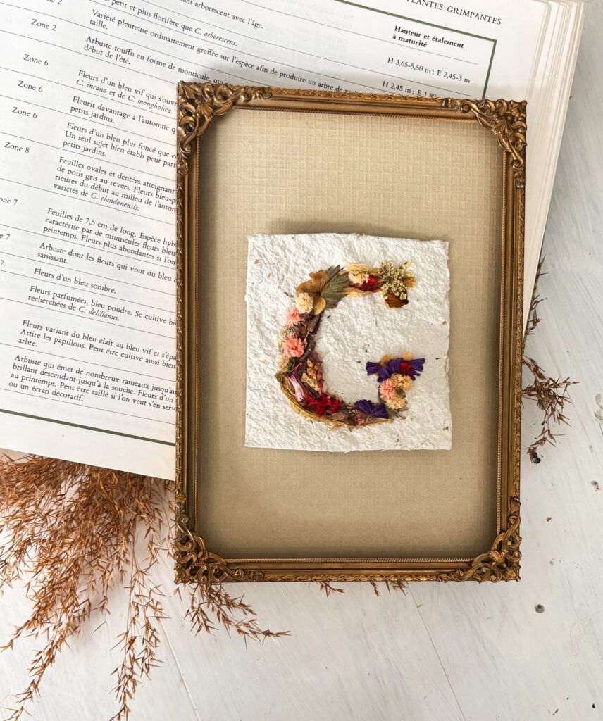 Lettrage artistique de la lettre G illustré avec des fleurs pressées et séchées, symbolisant les métiers commençant par G
