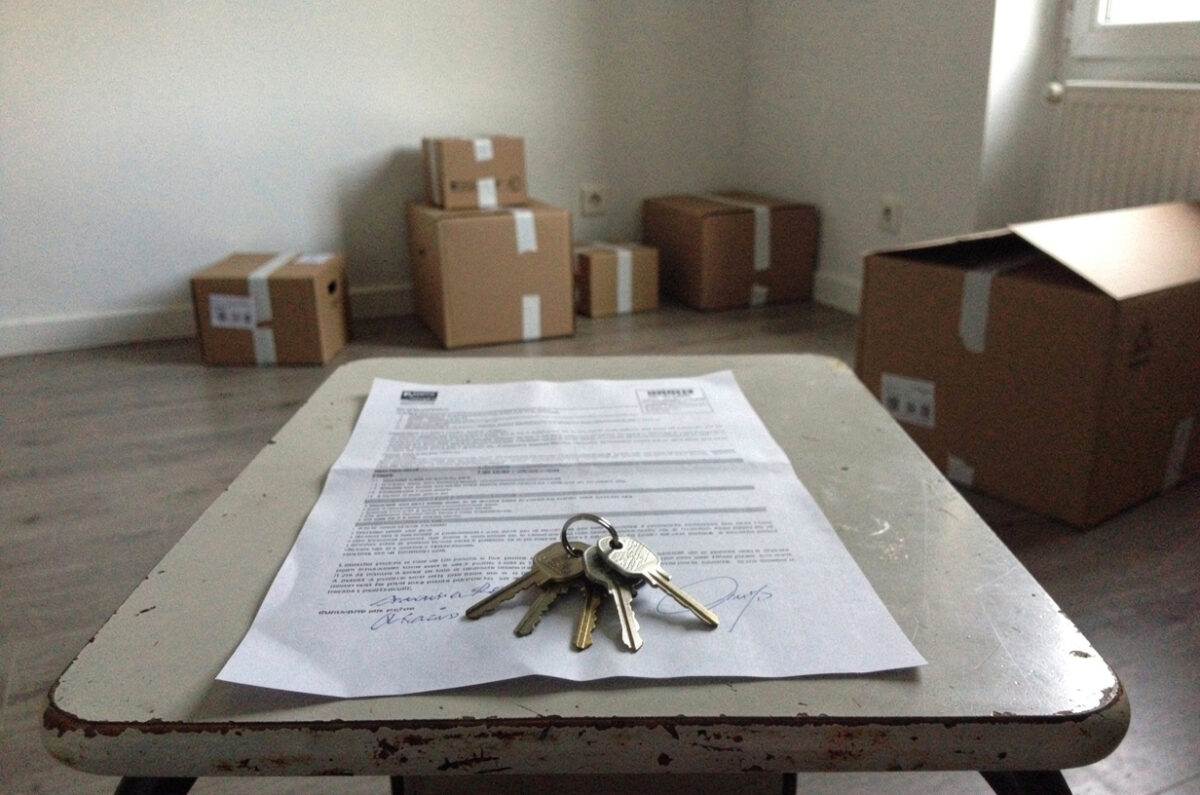 Bail signé et trousseau de clés sur une table dans un studio vide
