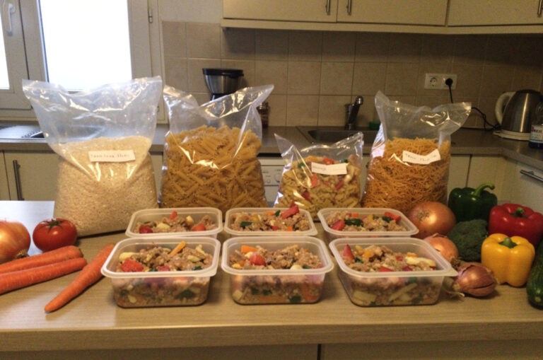 Plan de travail avec de grands sacs de riz et de pâtes et cinq boîtes-repas identiques