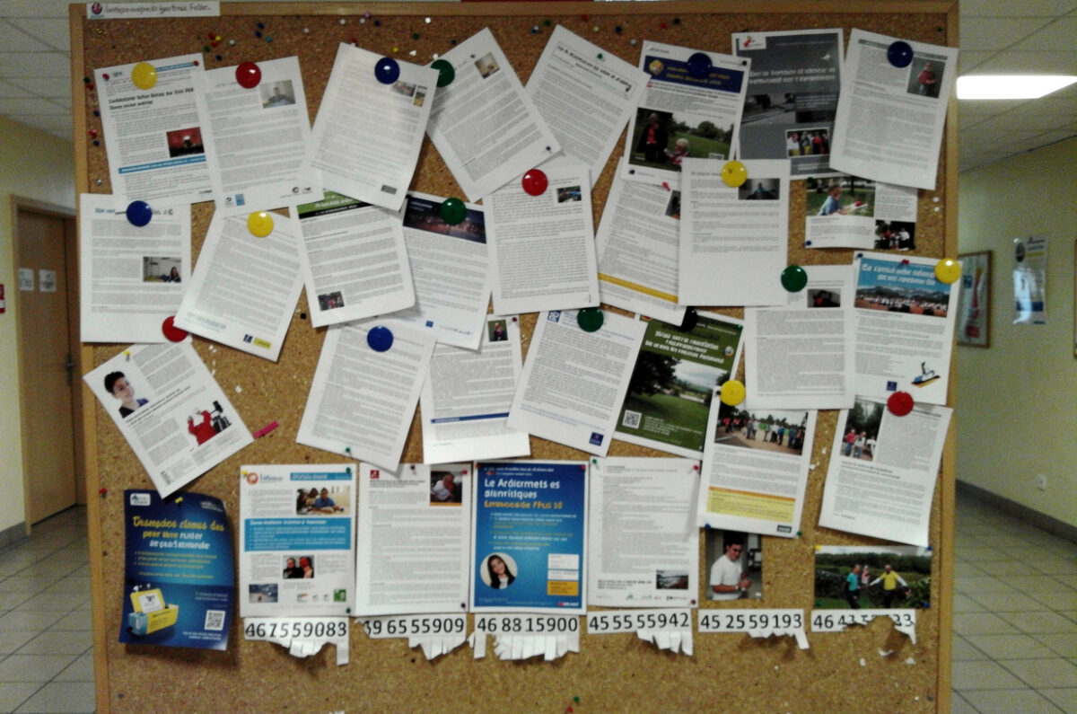 Panneau d'affichage couvert de feuilles punaisées dans le hall d'un établissement